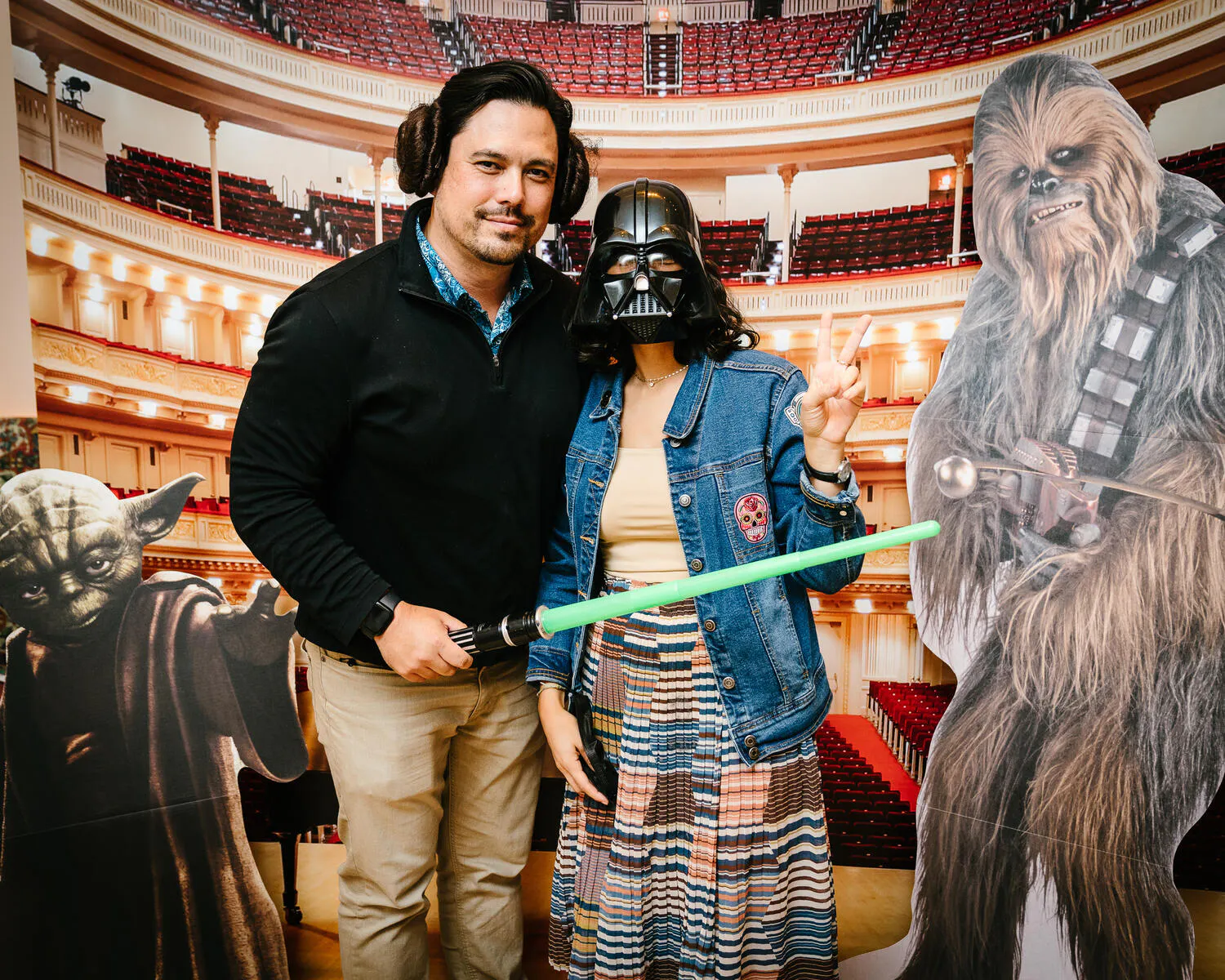 People posing in Star Wars costumes against a backdrop of Carnegie Hall.