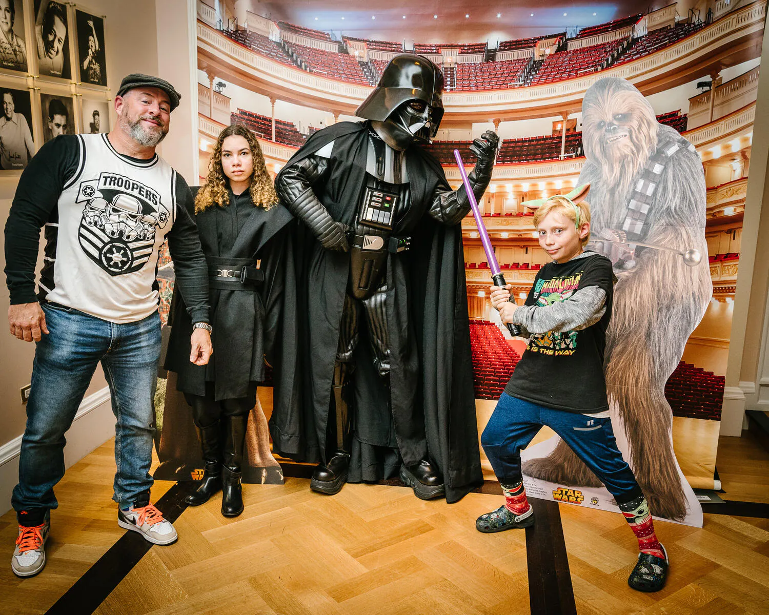 People posing in Star Wars costumes against a backdrop of Carnegie Hall.