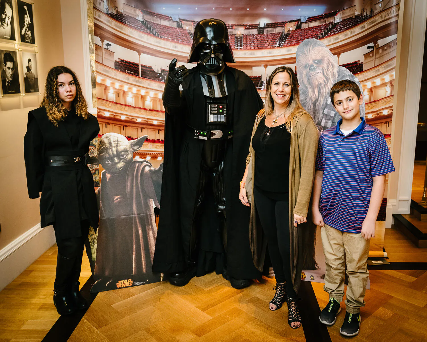 People posing in Star Wars costumes against a backdrop of Carnegie Hall.