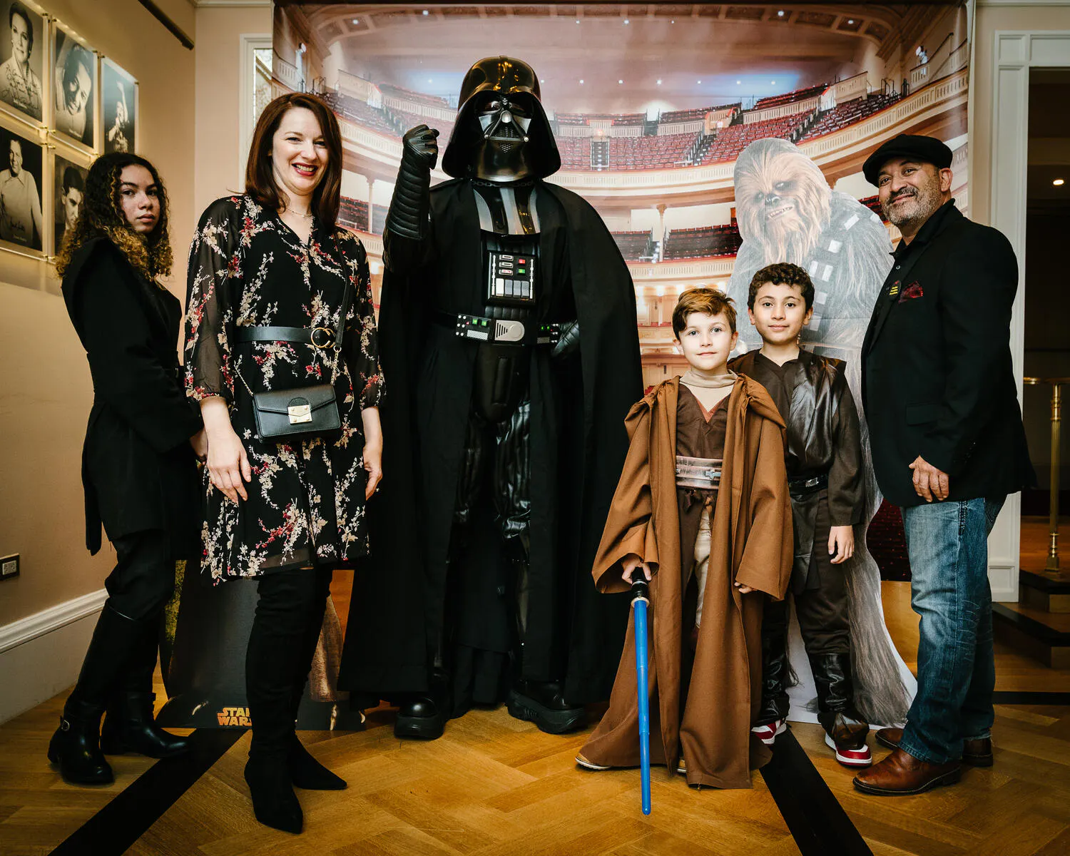 People posing in Star Wars costumes against a backdrop of Carnegie Hall.