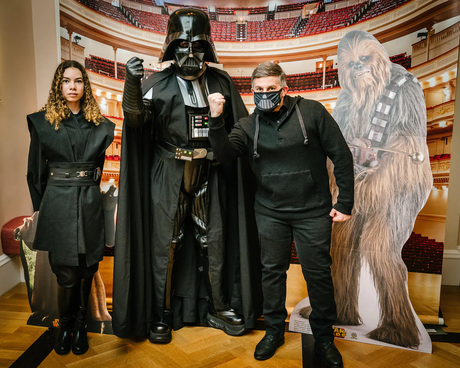 People posing in Star Wars costumes against a backdrop of Carnegie Hall.