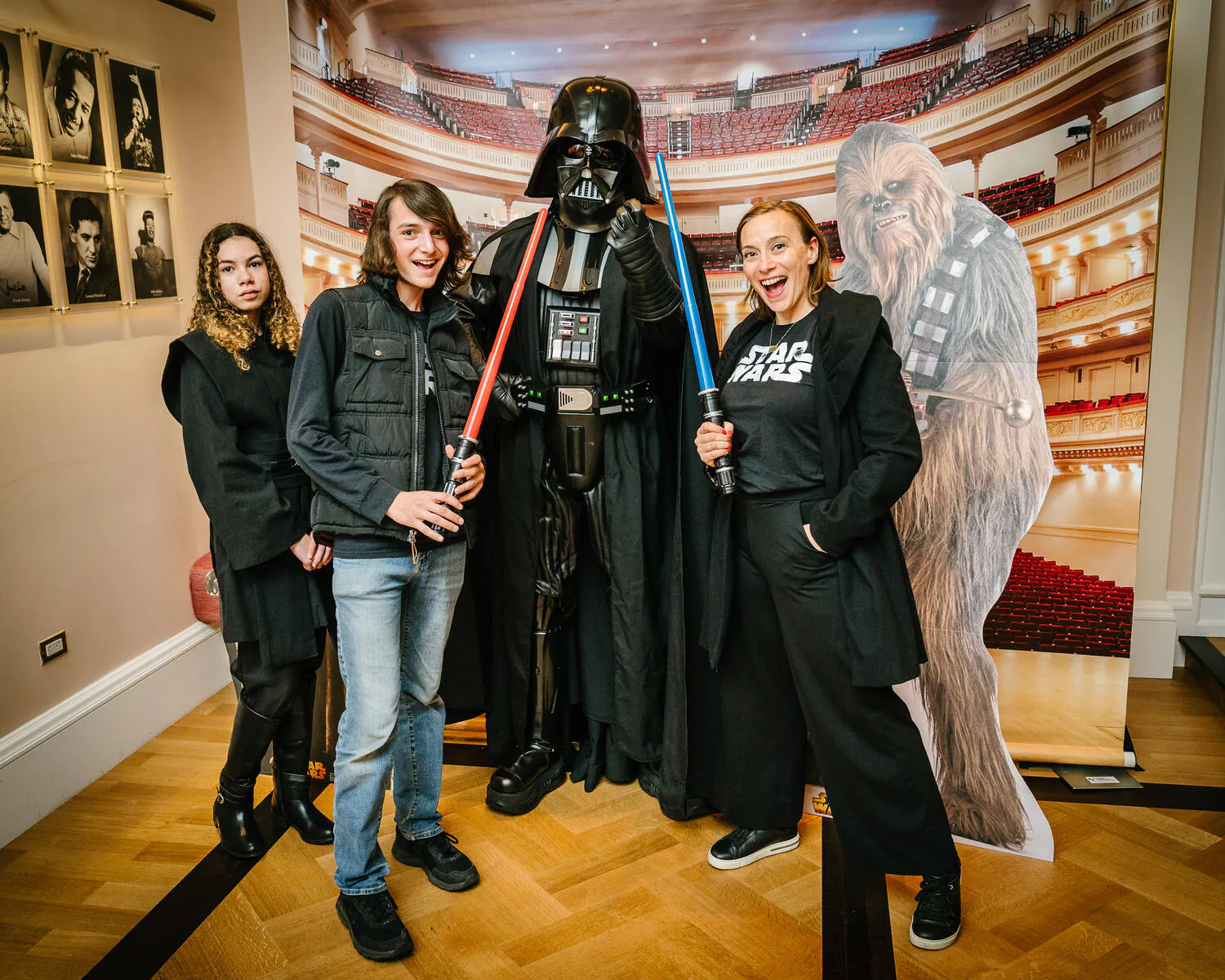 People posing in Star Wars costumes against a backdrop of Carnegie Hall.
