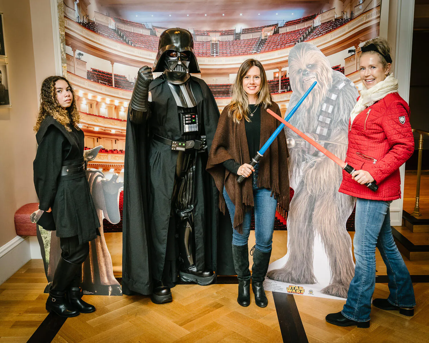 People posing in Star Wars costumes against a backdrop of Carnegie Hall.