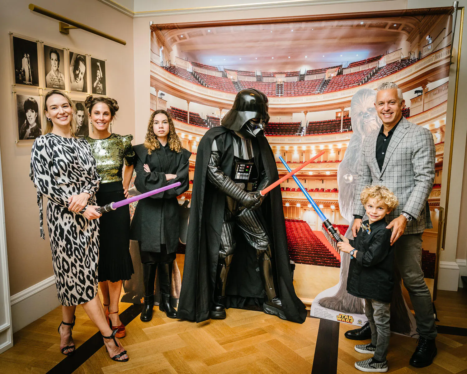 People posing in Star Wars costumes against a backdrop of Carnegie Hall.