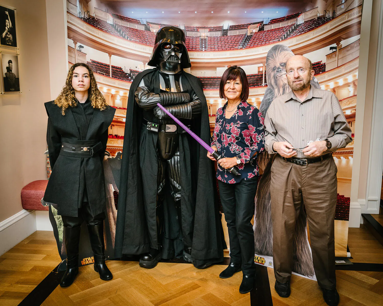 People posing in Star Wars costumes against a backdrop of Carnegie Hall.
