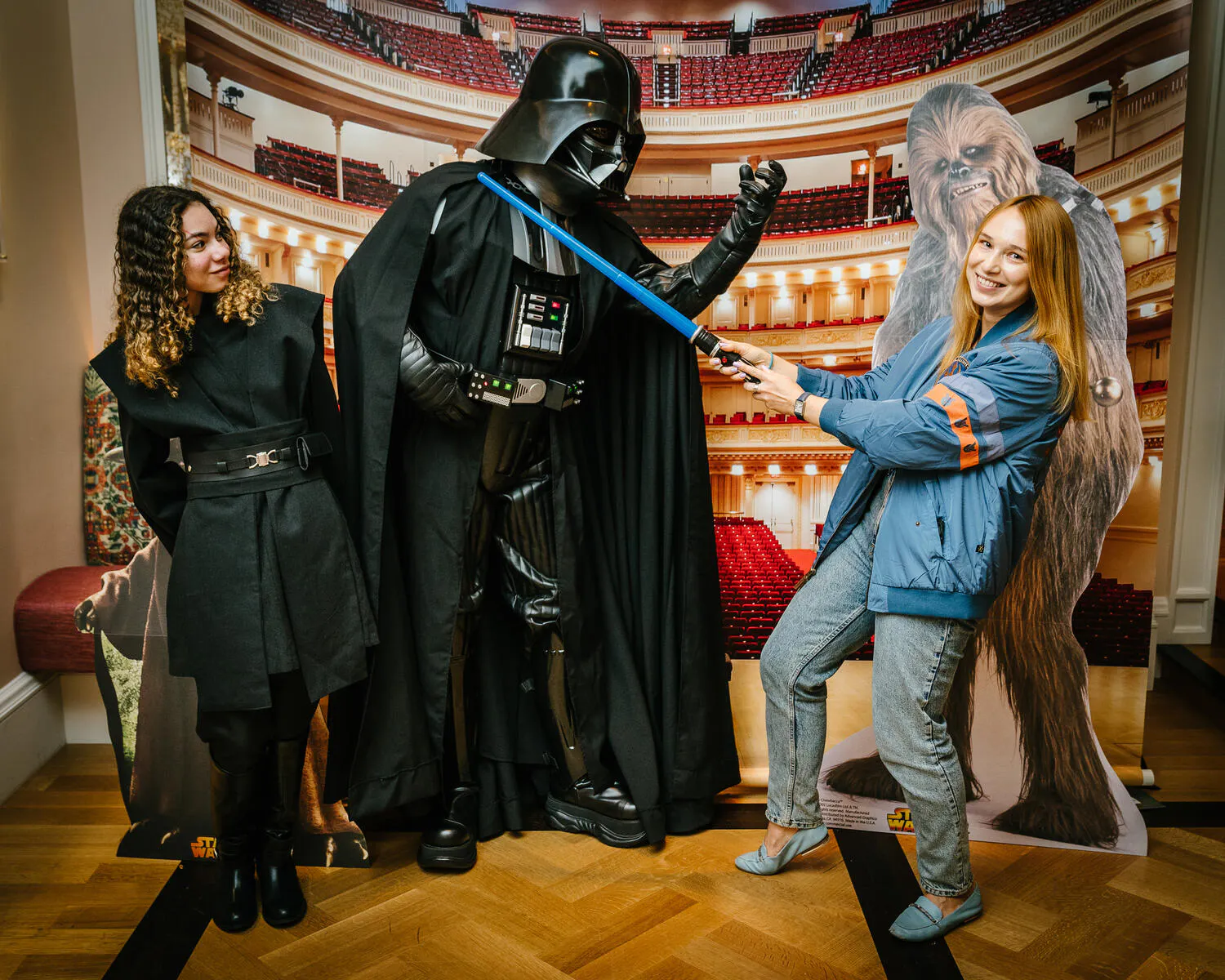 People posing in Star Wars costumes against a backdrop of Carnegie Hall.