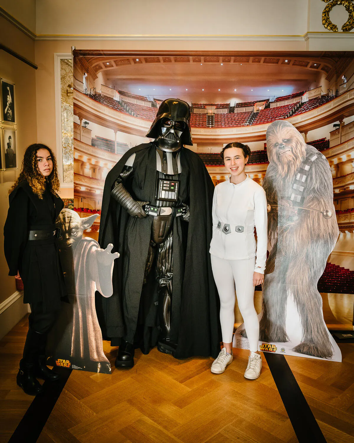 People posing in Star Wars costumes against a backdrop of Carnegie Hall.
