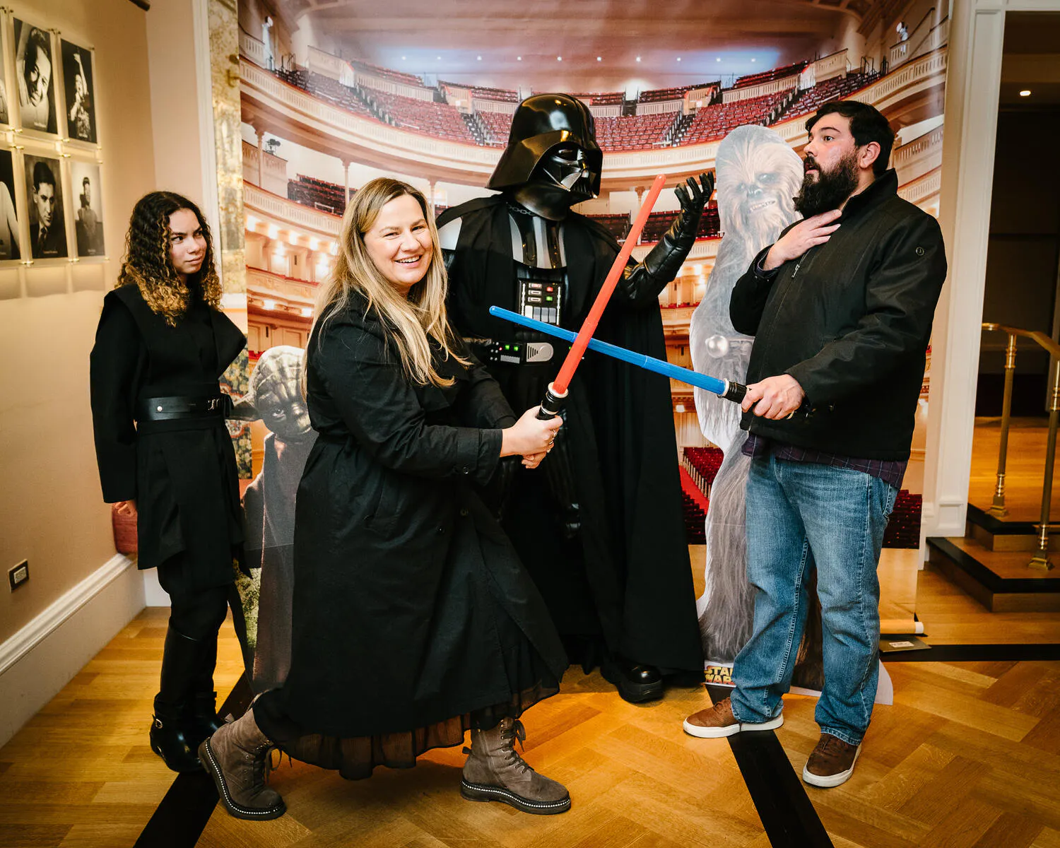 People posing in Star Wars costumes against a backdrop of Carnegie Hall.