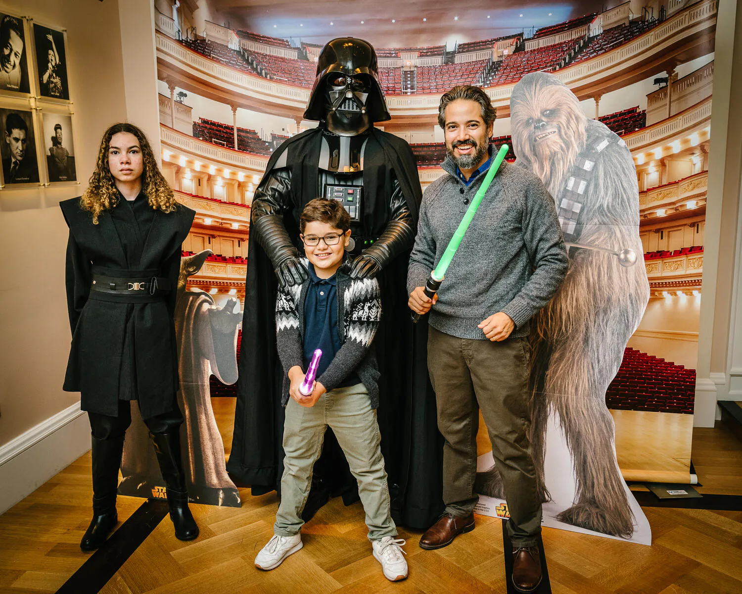 People posing in Star Wars costumes against a backdrop of Carnegie Hall.