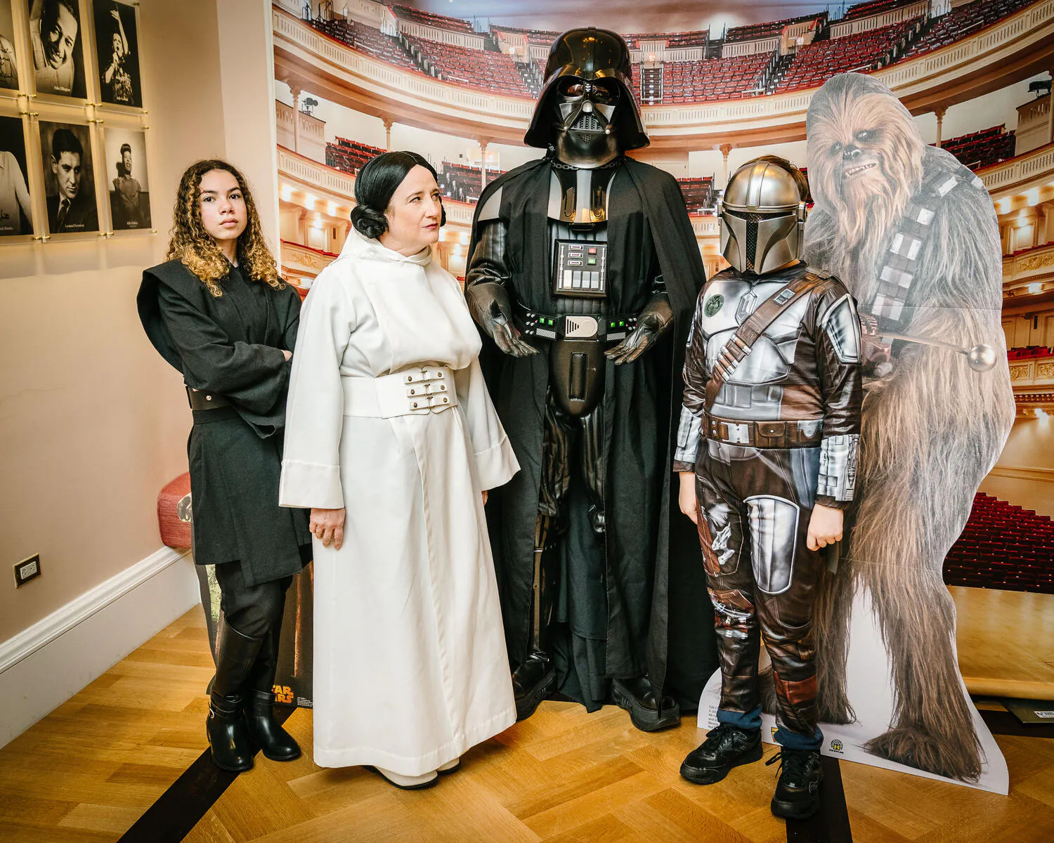 People posing in Star Wars costumes against a backdrop of Carnegie Hall.