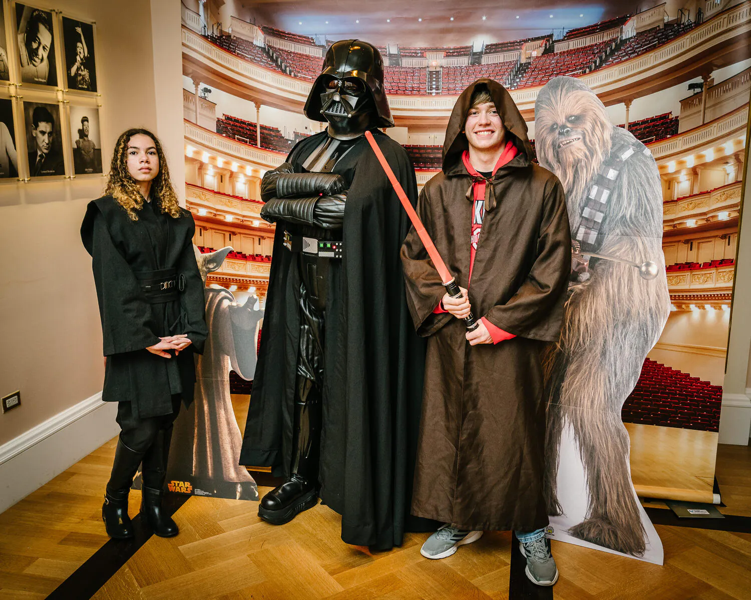People posing in Star Wars costumes against a backdrop of Carnegie Hall.