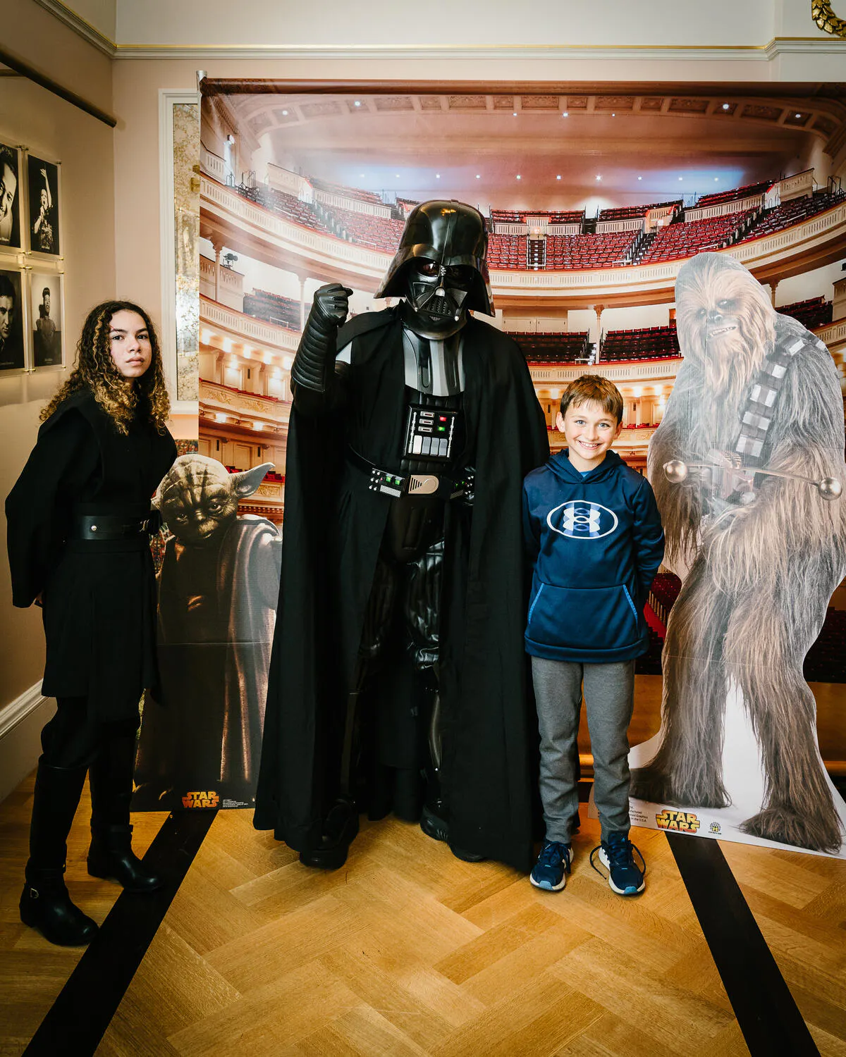 People posing in Star Wars costumes against a backdrop of Carnegie Hall.