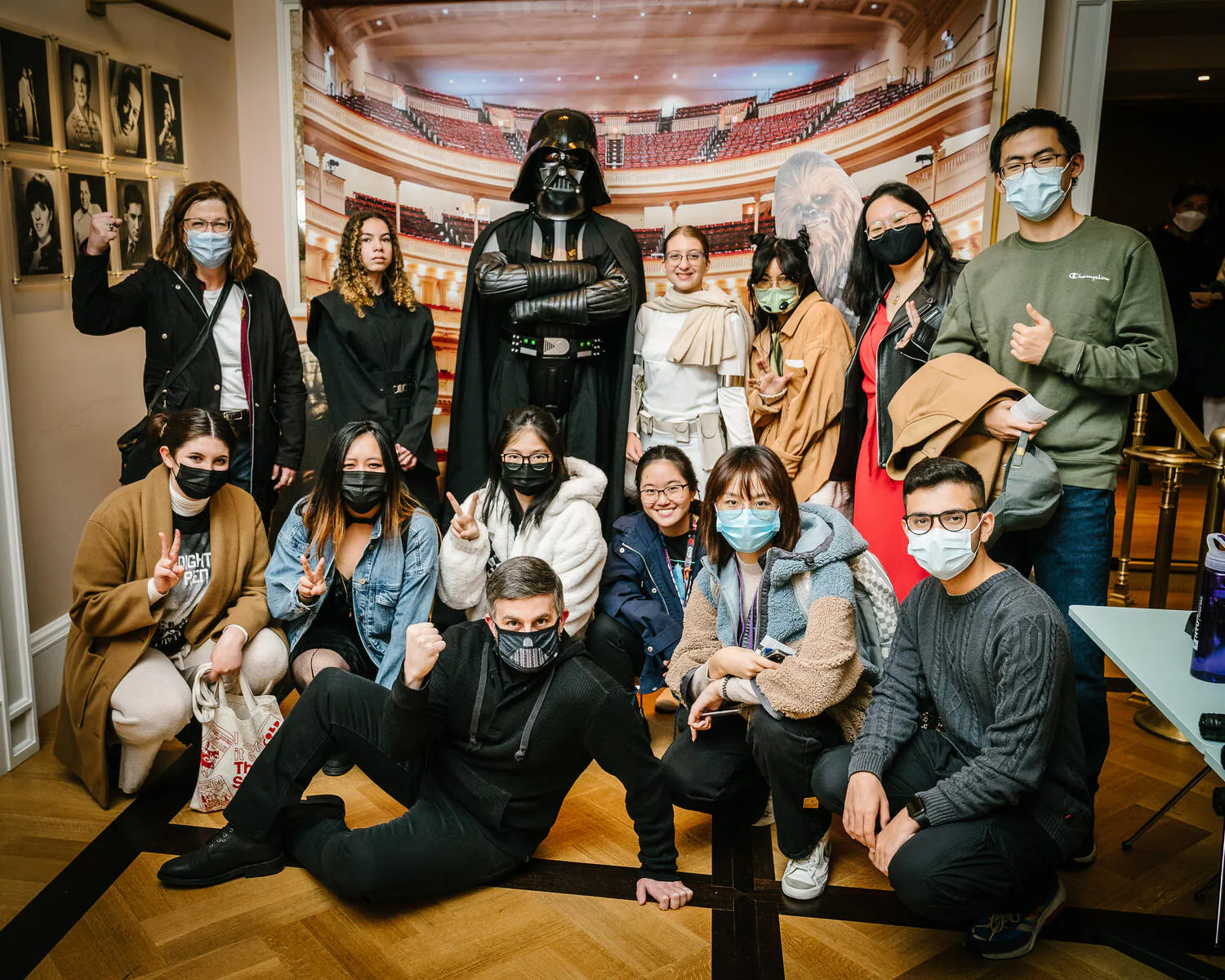 People posing in Star Wars costumes against a backdrop of Carnegie Hall.