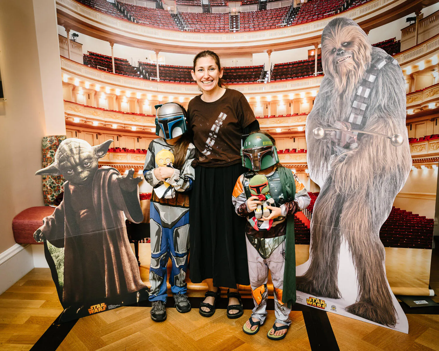 People posing in Star Wars costumes against a backdrop of Carnegie Hall.