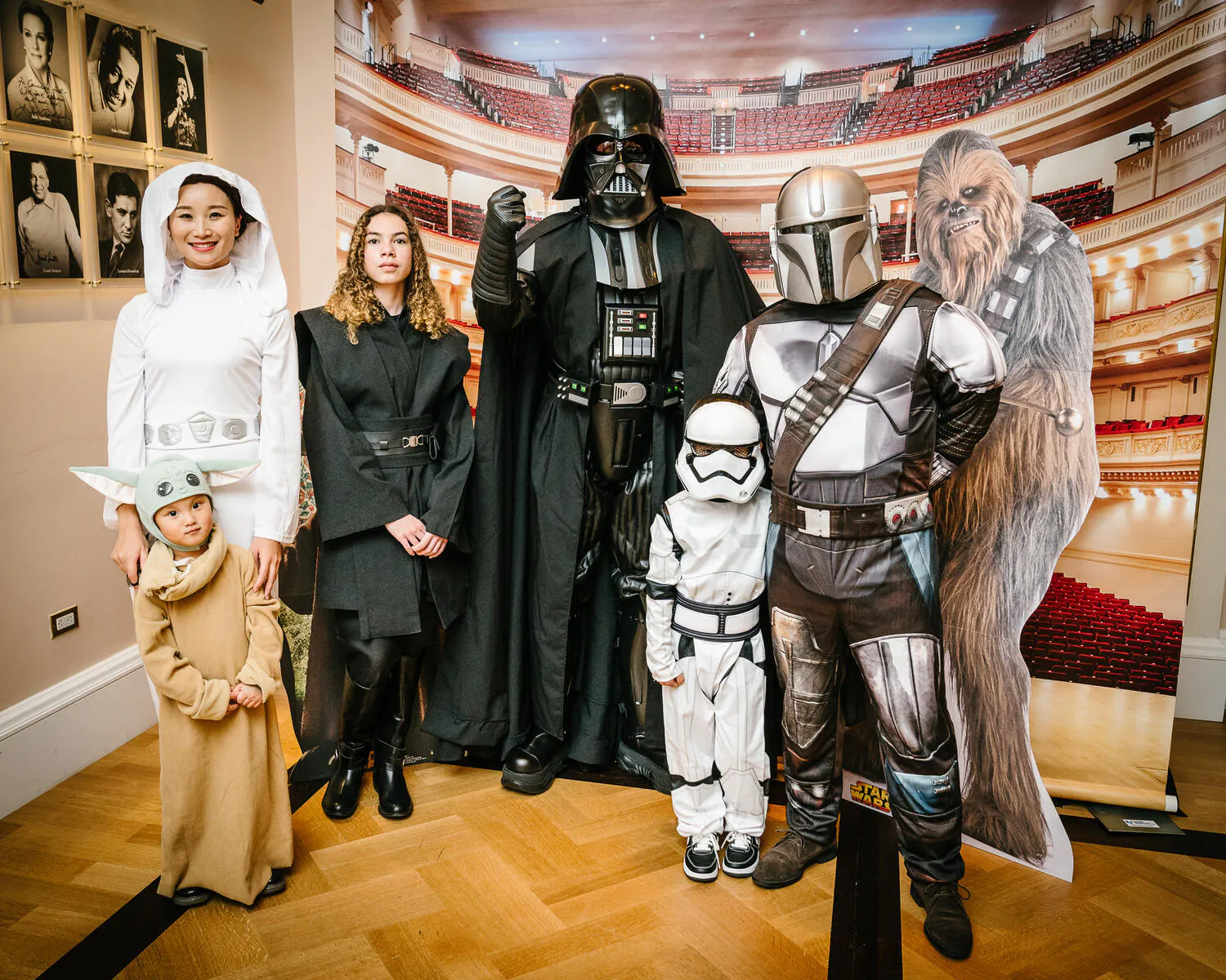A family poses in Star Wars costumes in front of a Carnegie Hall backdrop.