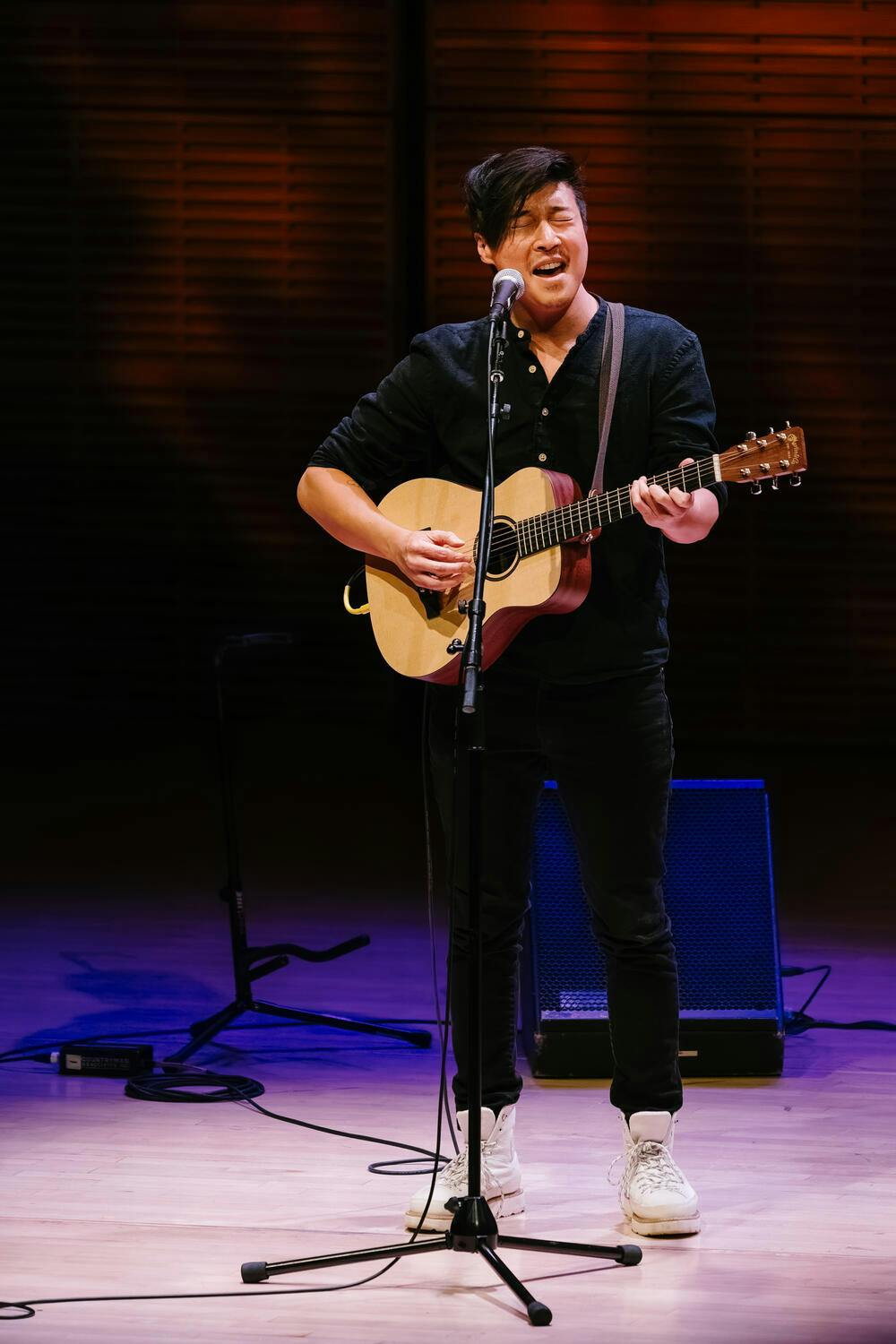 A man plays guitar in a microphone