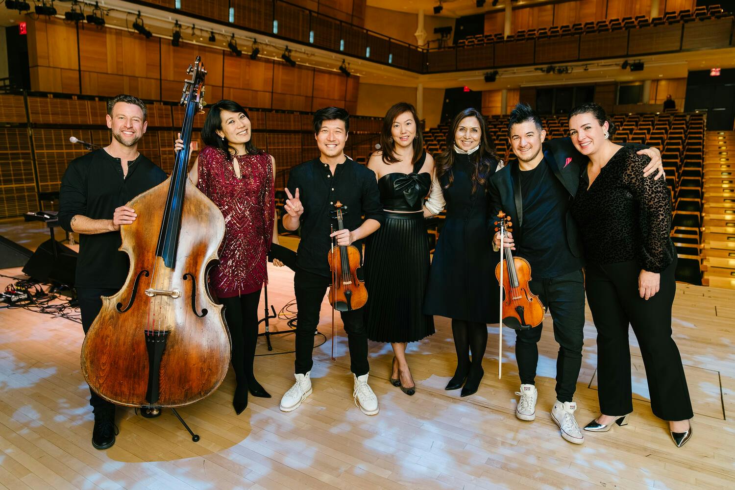 Musicians pose with their instruments on stage