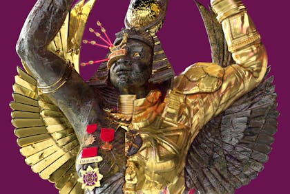 A black man with gold metal wings wearing an Egyptian headdress stands with arms upraised against a purple clouded sky