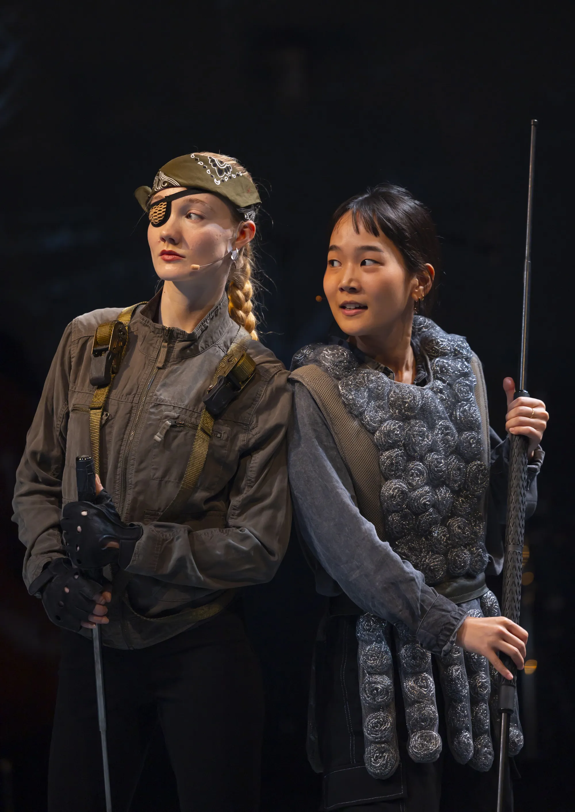 Two people standing and holding sticks