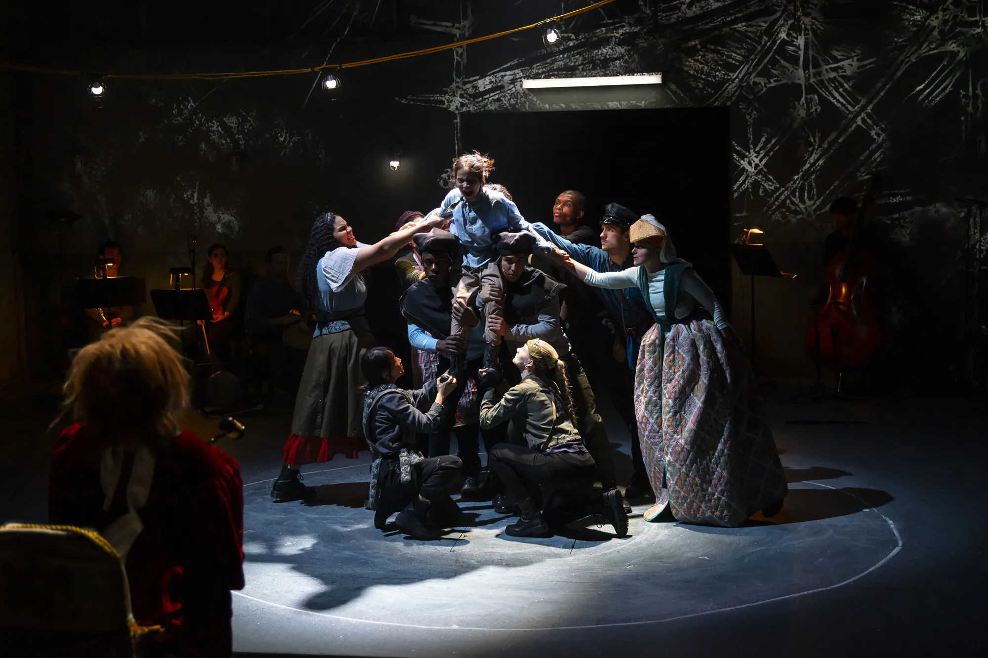 A group of people holding the arms and legs of a person, suspending them in the air