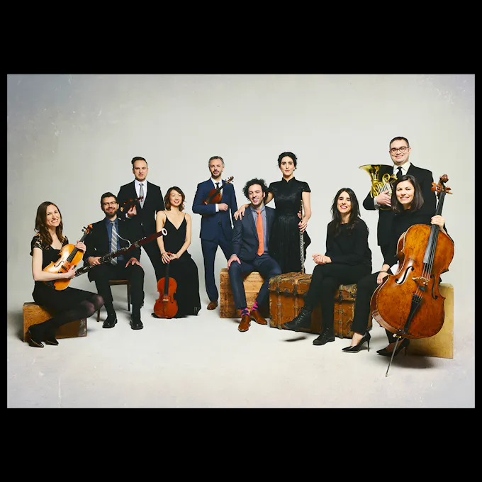 The Knights seated in a semicircle in formal attire with instruments