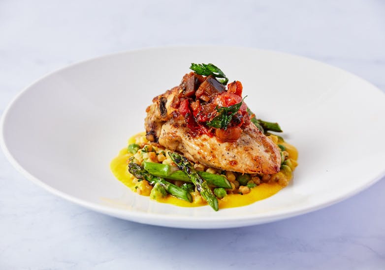 Grilled chicken and asparagus in a white dish