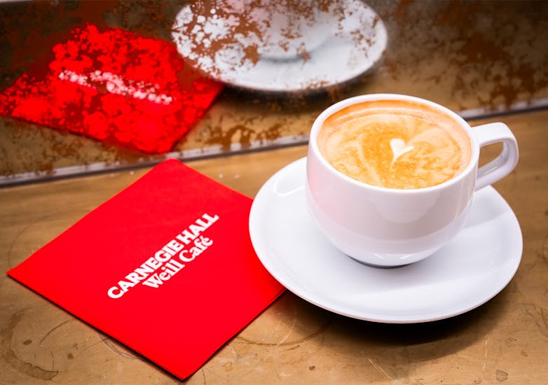 A laté with a heart-shaped design, and a Carnegie Hall napkin.