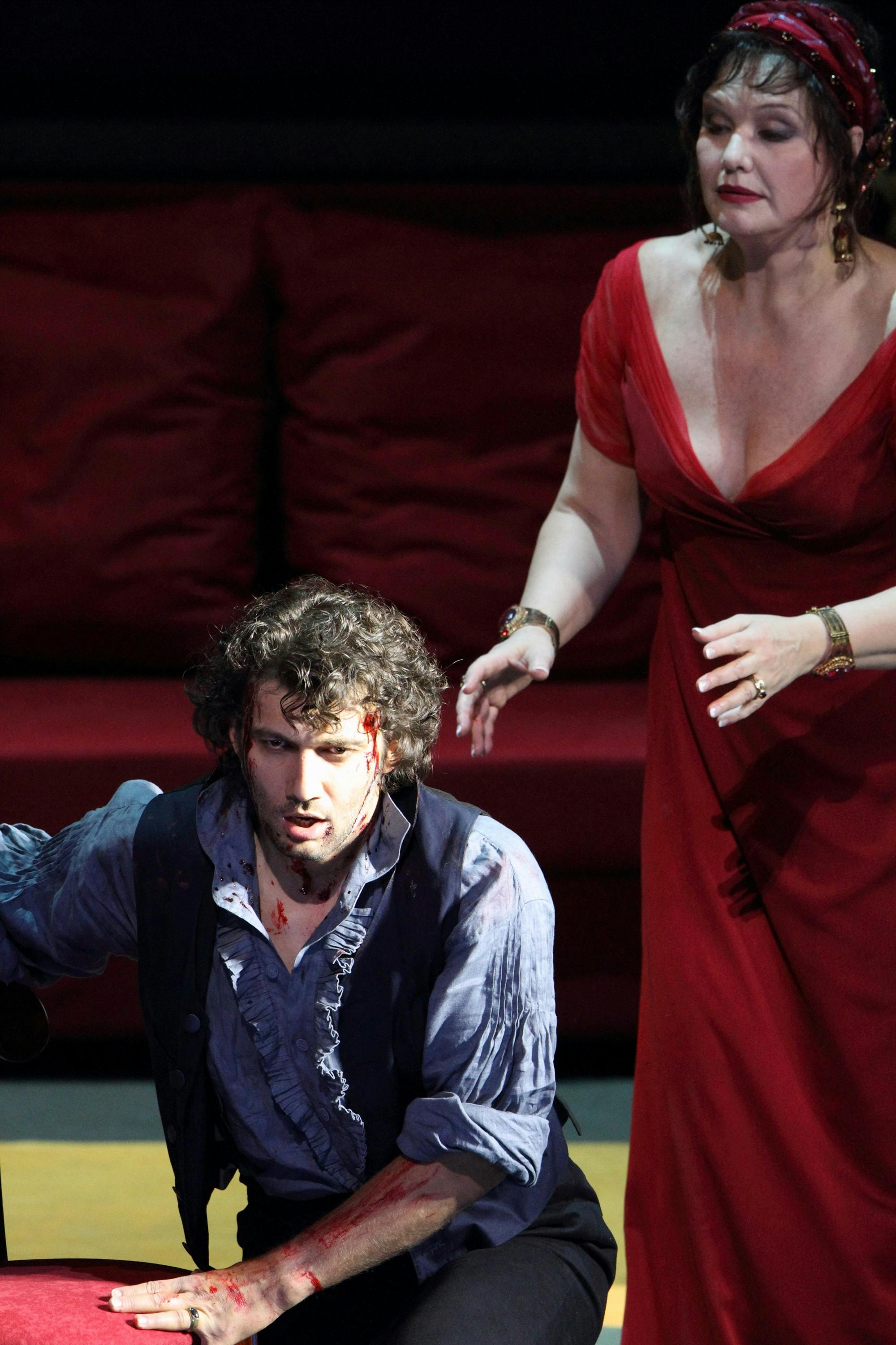 Jonas Kaufmann kneeling with Karita Mattila standing behind him.