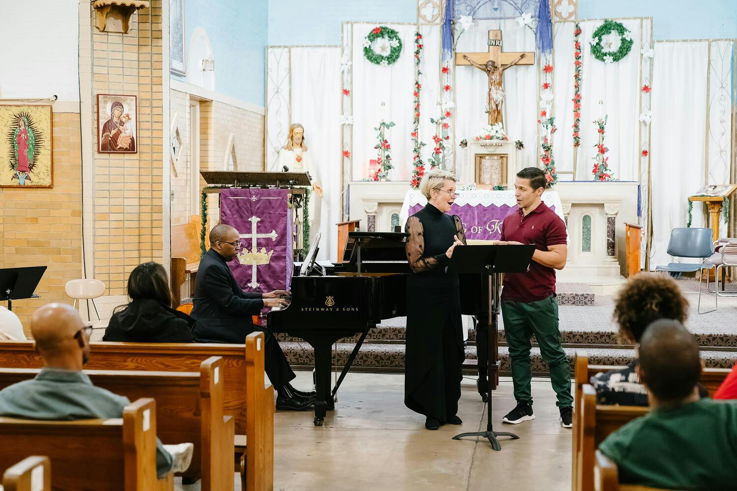 Joyce DiDonato, a vocalist, and a pianist performing for an audience in a church