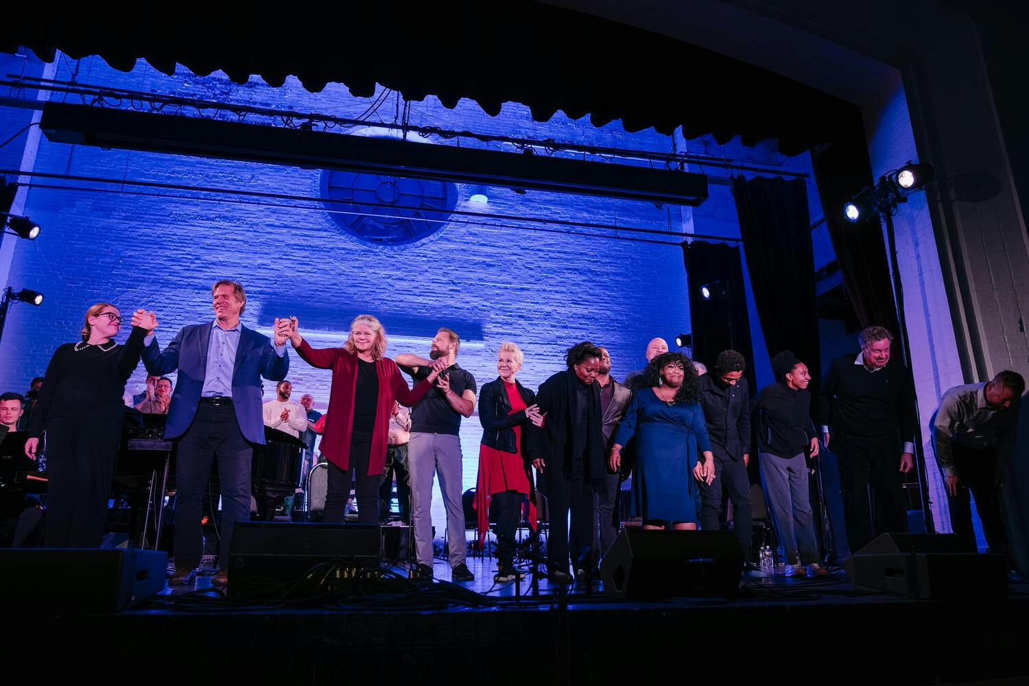Joyce DiDonato and musicians holding hands and bowing on stage