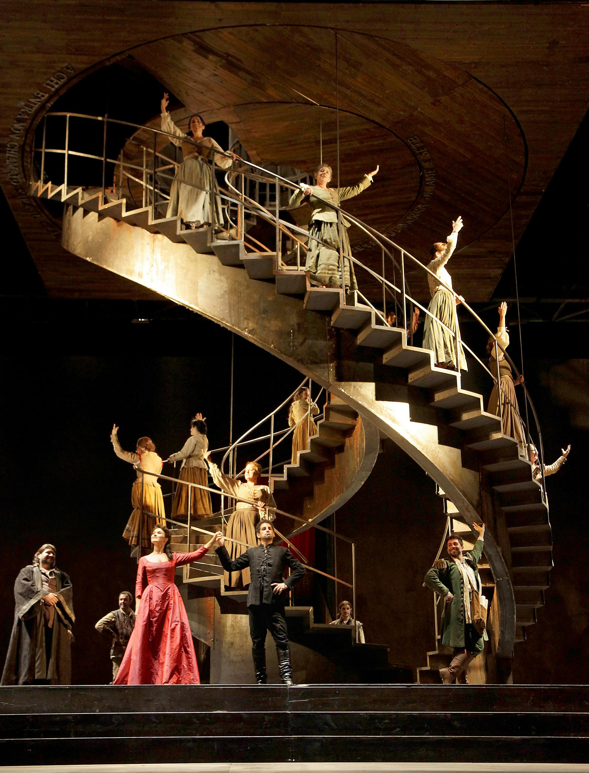 Two large spiral staircases, with performers standing on the steps and on stage.