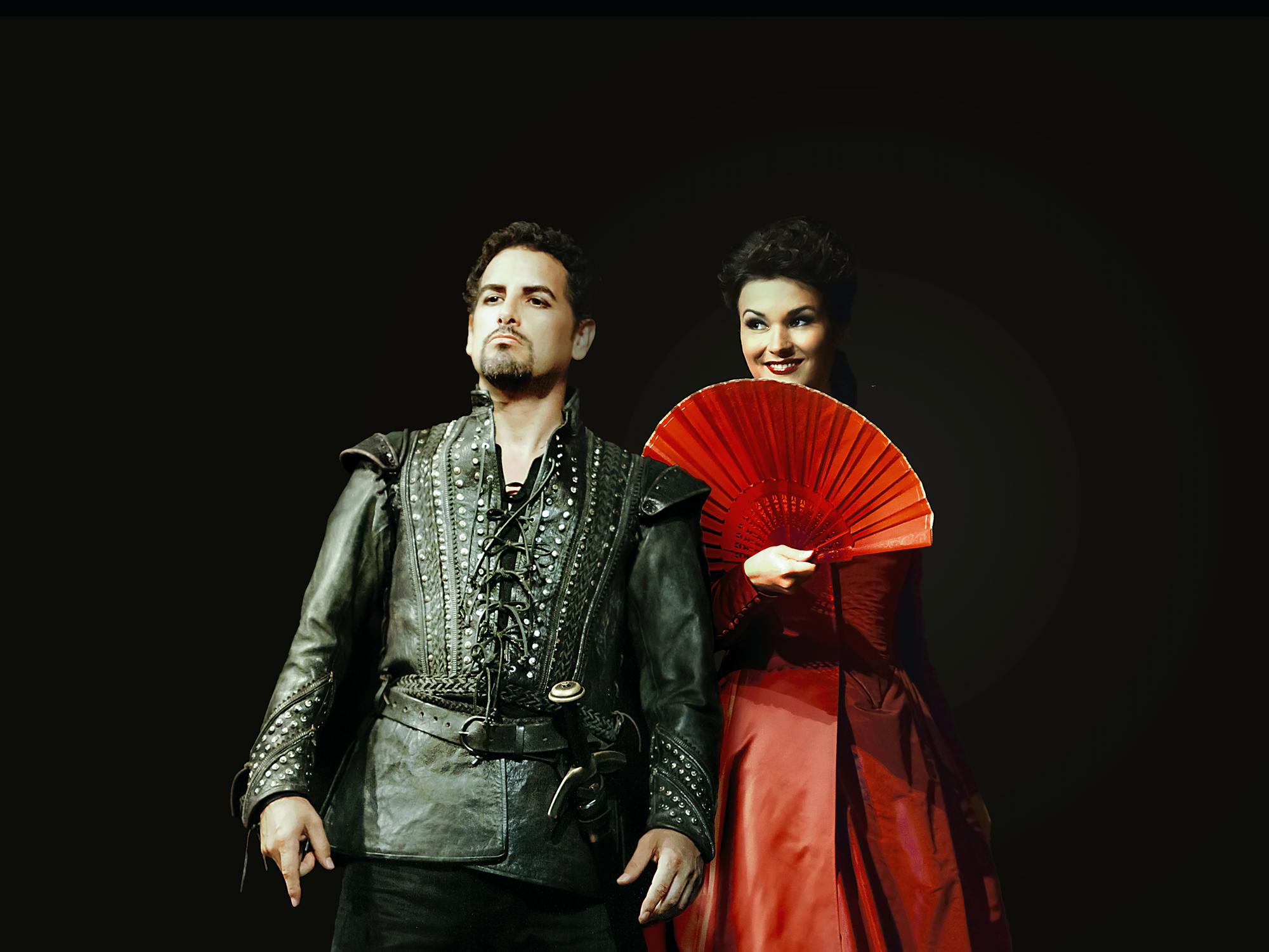 Juan Diego Flórez standing in front of Olga Peretyatko, who is holding a fan.