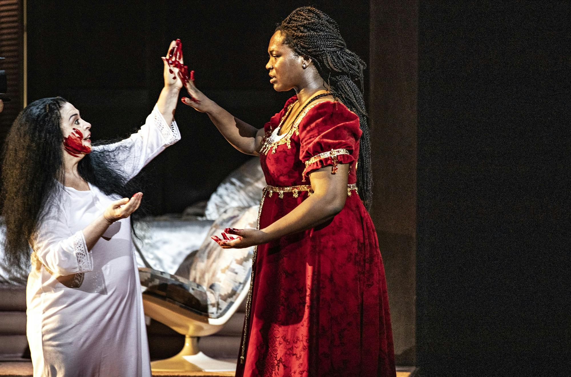 Angel Blue touching hands with another person with blood on their hands and face