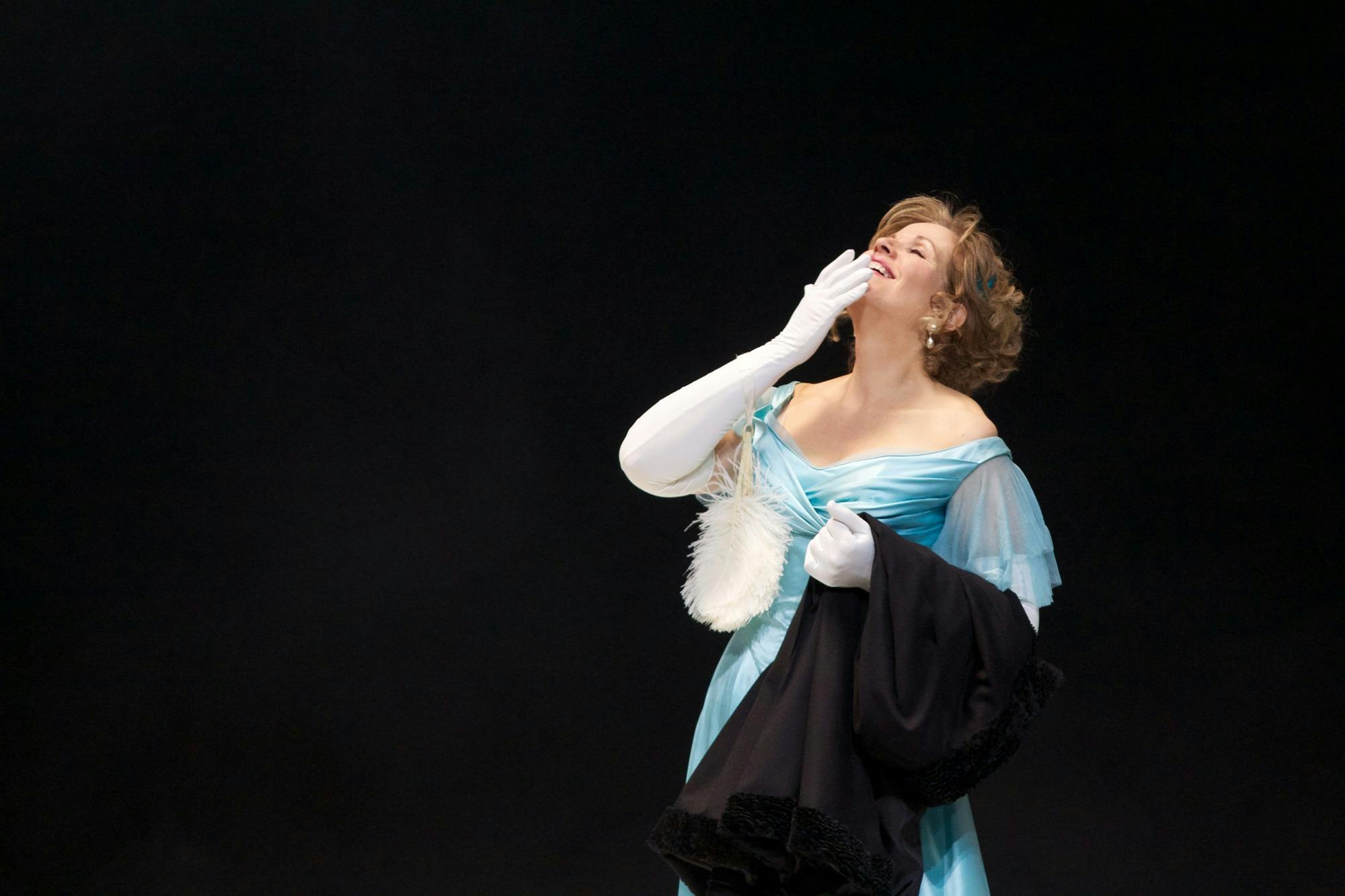 Renée Fleming looking upwards with a hand on her mouth