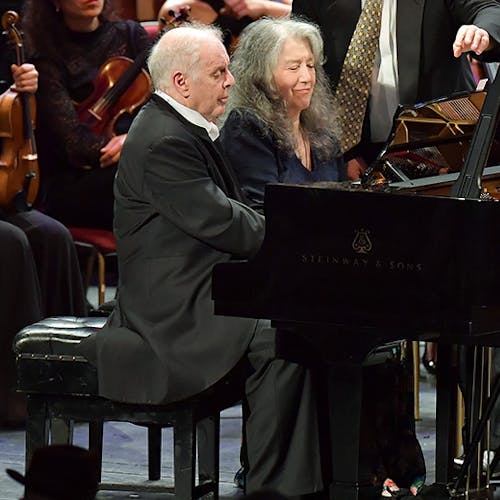 Daniel Barenboim and Martha Argerich performing on the same piano with an orchestra
