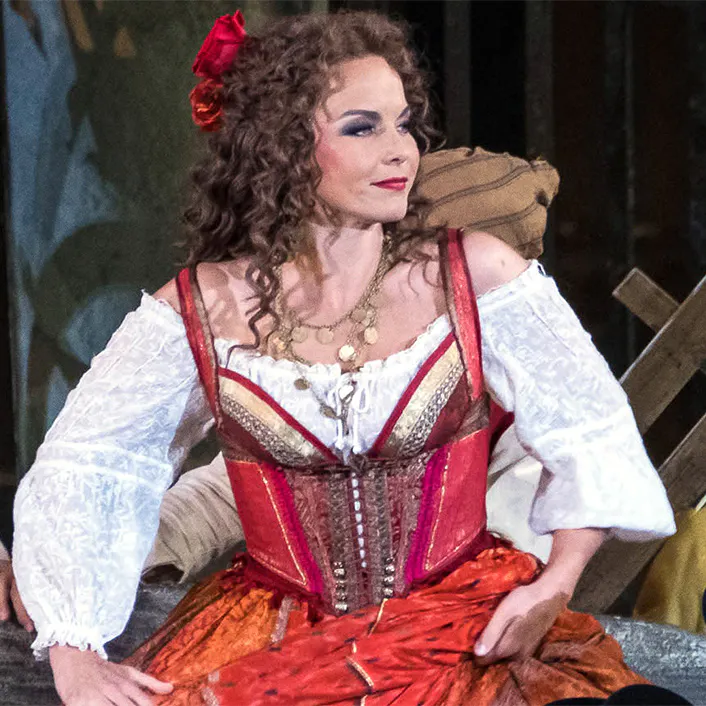 A performer in a red and white dress, and another performer on stage