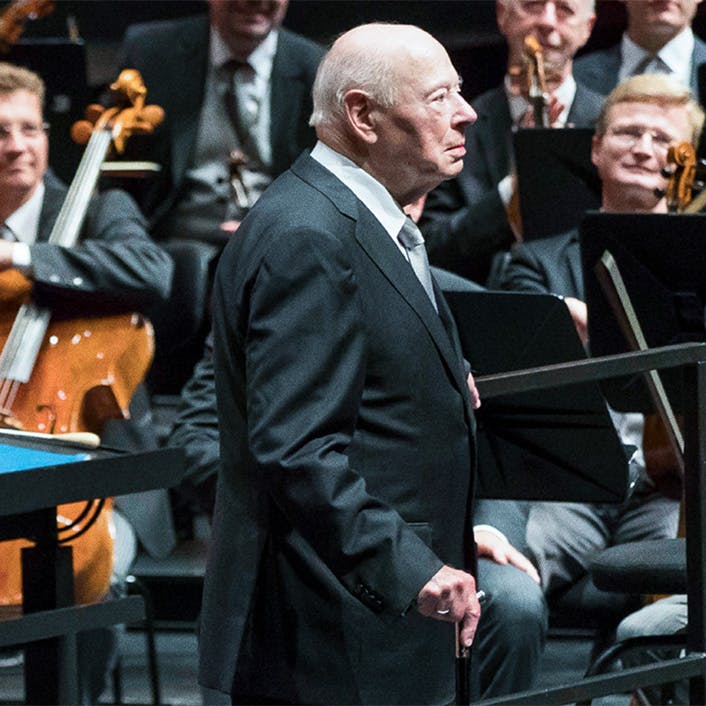 Bernard Haitink standing in front of an orchestra