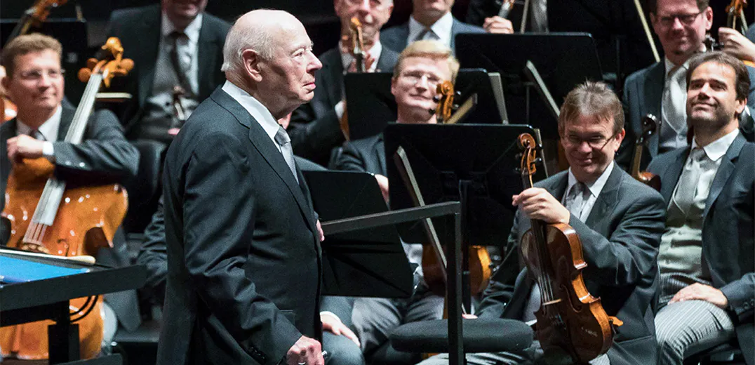 Bernard Haitink standing in front of an orchestra