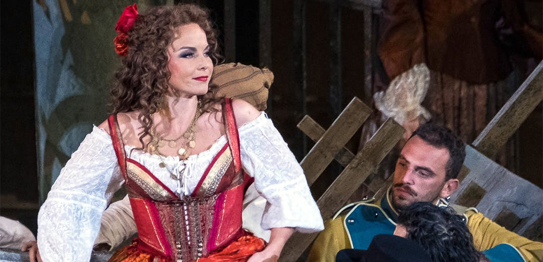 A performer in a red and white dress, and another performer on stage