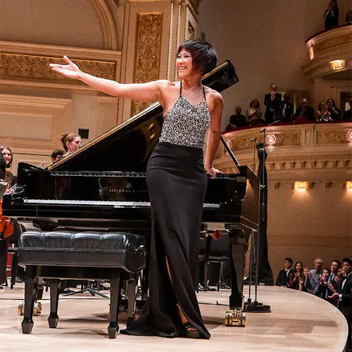 Yuja Wang and the NYO-USA All Stars standing on stage for applause