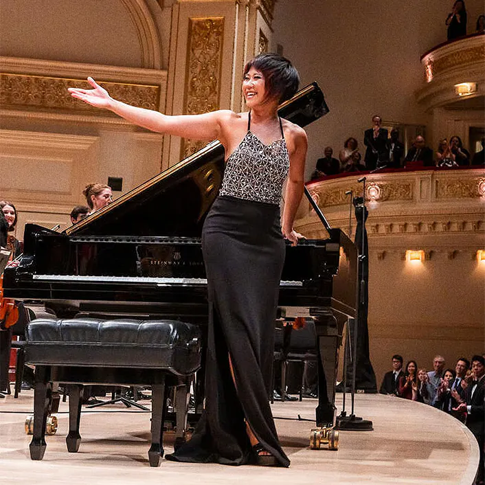 Yuja Wang and the NYO-USA All Stars standing on stage for applause