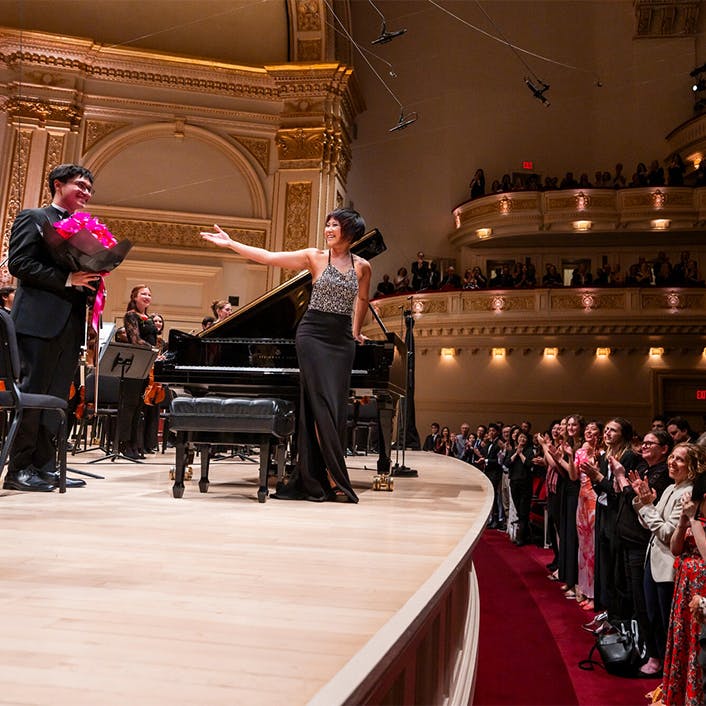 Yuja Wang and the NYO-USA All Stars standing on stage for applause