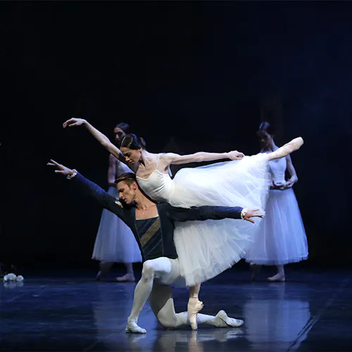 Two dancers on stage with arms and legs extended