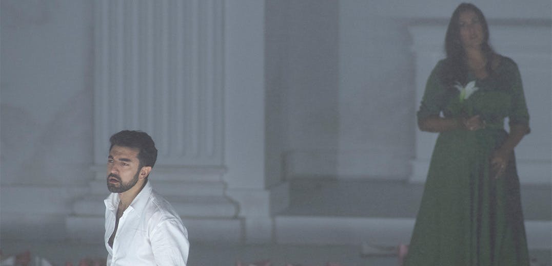 Two people standing in a grey room