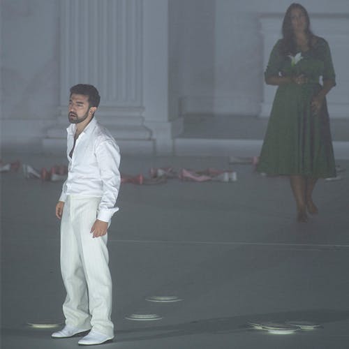 Two people standing in a grey room