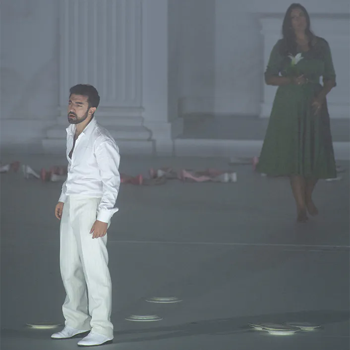 Two people standing in a grey room