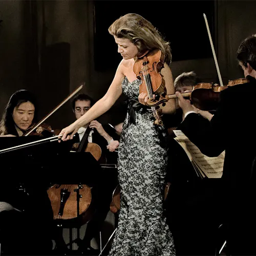 Anne-Sophie Mutter holding the violin on stage.