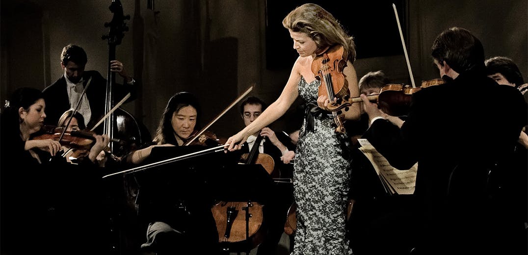 Anne-Sophie Mutter holding the violin on stage.