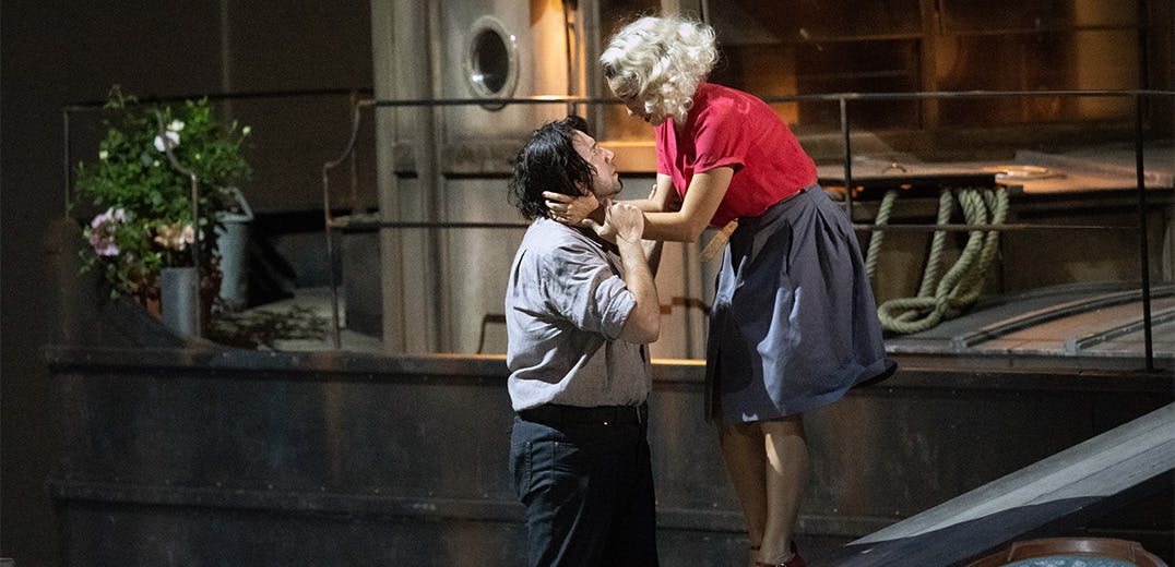 Two people standing and holding one another