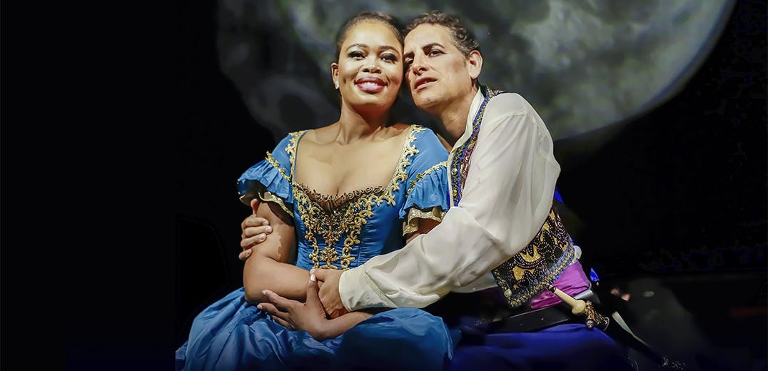 Pretty Yende and Juan Diego Flórez kneeling on stage holding one another